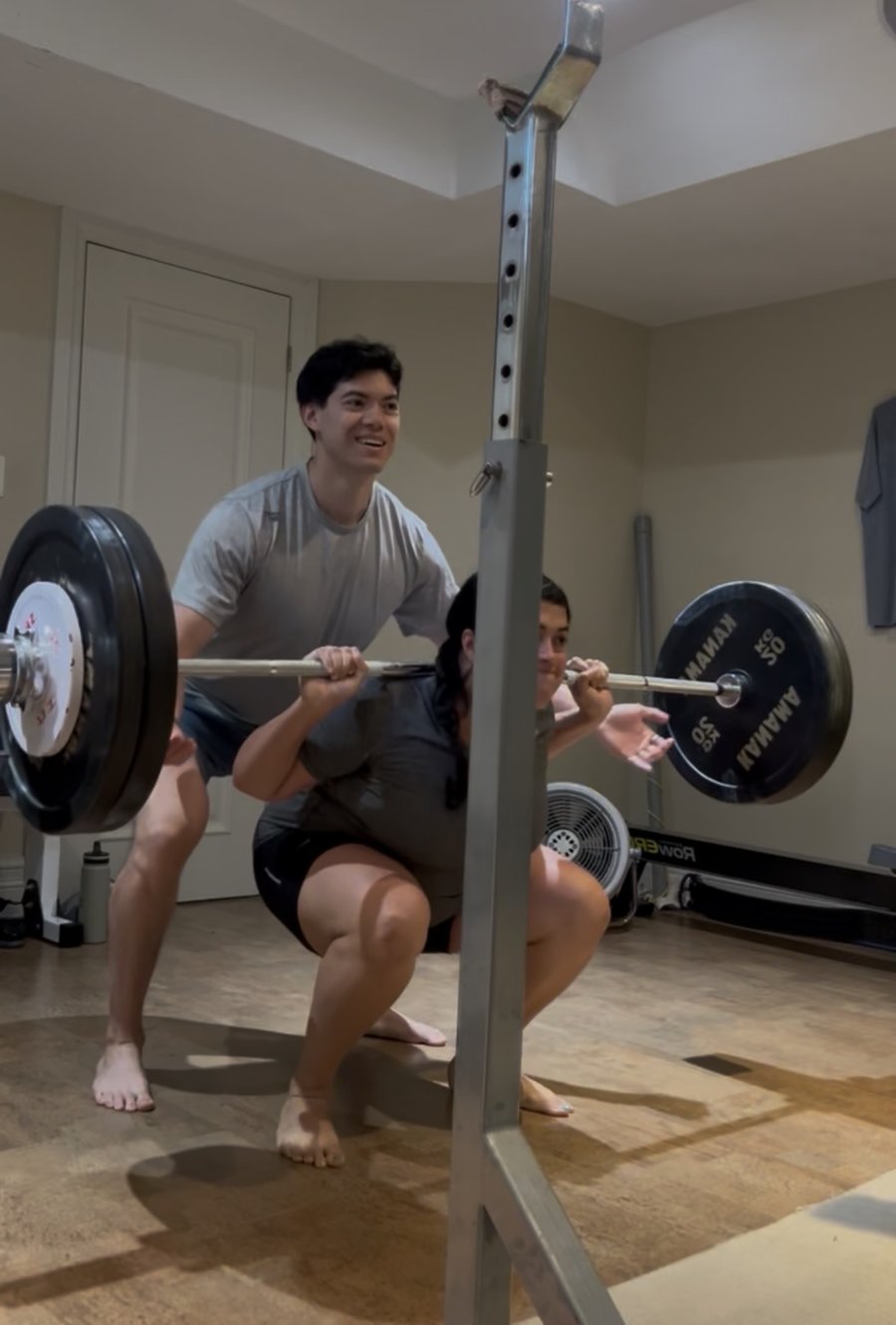 Barbell squat with a trainer spotting
