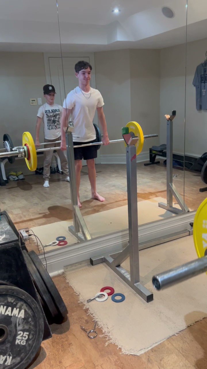 Two younger athletes training with a barbell